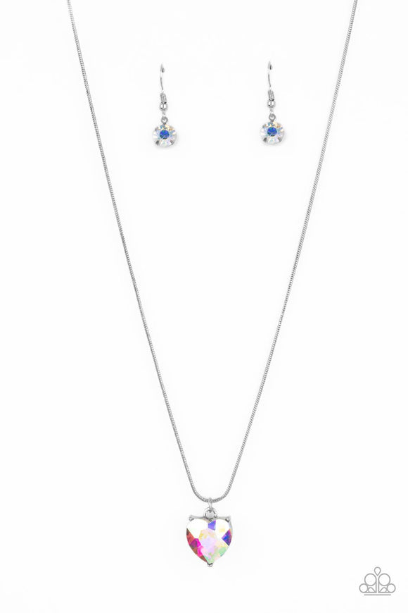 A heart-shaped rhinestone brushed in a reflective iridescent finish sparkles brilliantly as it slides along a skinny silver snake chain. The gem is pressed into a thick silver frame, allowing its faceted surface to be emphasized. Features an adjustable clasp closure. Due to its prismatic palette, color may vary.  Sold as one individual necklace. Includes one pair of matching earrings.
