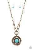 A circle of glassy white rhinestones fans out around an oversized turquoise stone, centered atop a warped brass disc. Etched with linear details, the earthy pendant attaches to oversized brass links, creating an artisan-inspired statement piece. Features an adjustable clasp closure.  Sold as one individual necklace. Includes one pair of matching earrings.