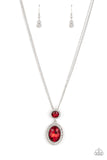 A large oval red rhinestone is encased in a border of rhinestone-dusted silver, as it's suspended from a smaller version of the same design. The stacked pendant then slides along a pair of silver chains in a regal finish. Features an adjustable clasp closure.  Sold as one individual necklace. Includes one pair of matching earrings