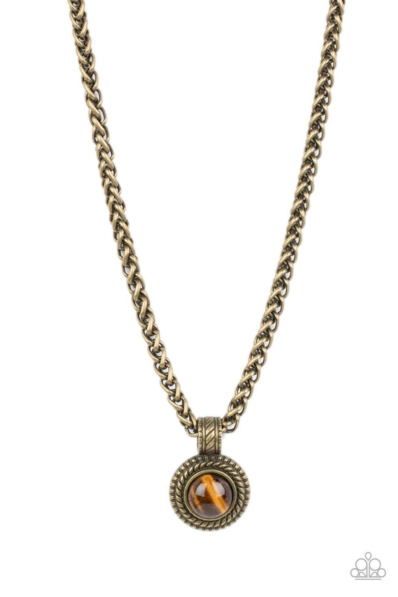 A textured brass frame spins around a tiger's eye stone center, creating a tranquil statement piece. The reflective pendant is anchored by a textured brass fixture, adding eye-catching dimension as the pendant slides along a thick strand of brass wheat chain. Features an adjustable clasp closure. As the stone elements in this piece are natural, some color variation is normal.  Sold as one individual necklace.