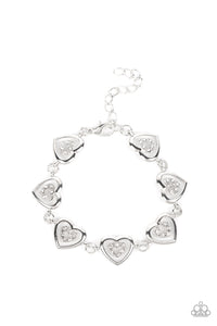 Dotted with dainty white rhinestones, airy silver heart silhouettes are affixed to the points of larger silver heart frames. The two dimensional heart frames link together around the wrist in a flirtatious finish. Features an adjustable clasp closure.  Sold as one individual bracelet.