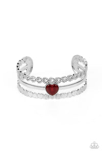 Three bands of silver arc across the wrist to create a romantic-inspired cuff. A row of white rhinestone-studded hearts are turned on their sides, gracing the top band of the cuff while solid silver hearts alternate end-over-end to create the bottom band. A sleek bar of silver topped with a red, heart-shaped, cat's eye stone falls between the outer bands, emerging as a polished focal point in a whimsical finish.  Sold as one individual bracelet.