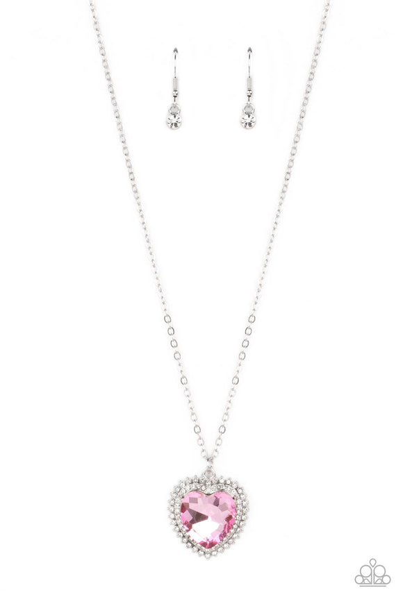 A pink crystal-like heart gem sparkles dramatically as it's wrapped in a glassy white rhinestone-studded heart frame. Adding additional shimmer, a second layer of white rhinestones encircles the studded pendant as it swings from a classic silver chain in a flirty finish. Features an adjustable clasp closure.  Sold as one individual necklace. Includes one pair of matching earrings.