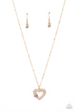 A luxurious airy gold heart lush with glassy white rhinestones swings from a classic gold chain. A faceted heart gem brushed in an iridescent shimmer graces one side of the larger bedazzled heart for a romantic finish. Features an adjustable clasp closure. Due to its prismatic palette, color may vary.  Sold as one individual necklace. Includes one pair of matching earrings.