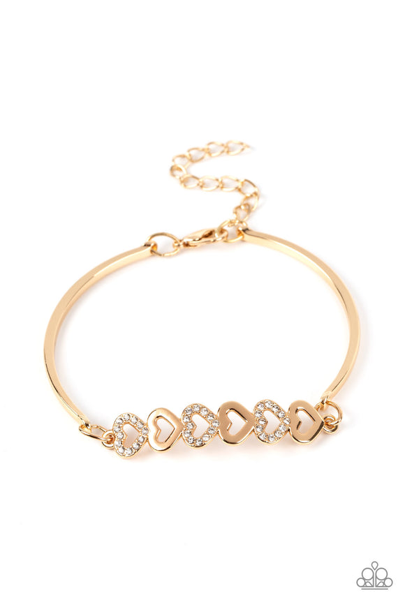 Gold, heart-shaped silhouettes are tilted on their sides, falling in line with variations of the same gold frames encrusted in white rhinestones. The alternating pattern of metallic sheen and glittery shimmer adds eye-catching detail, as the hearts connect into a curved pendant that curls around the wrist. Features an adjustable clasp closure.  Sold as one individual bracelet.