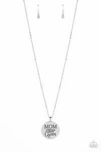 At the bottom of a shiny silver chain, a shiny silver disc is stamped with the phrase, "MOM a title just above Queen". The clasp attaching the disc to the chain features a collection of dainty white rhinestones, adding a hint of sparkle to the sentimental statement piece. Features an adjustable clasp closure.  Sold as one individual necklace. Includes one pair of matching earrings.