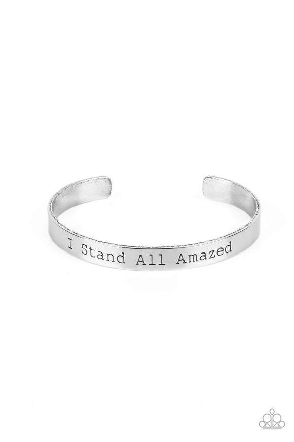 A simplistic, shiny, silver cuff is stamped with the phrase 