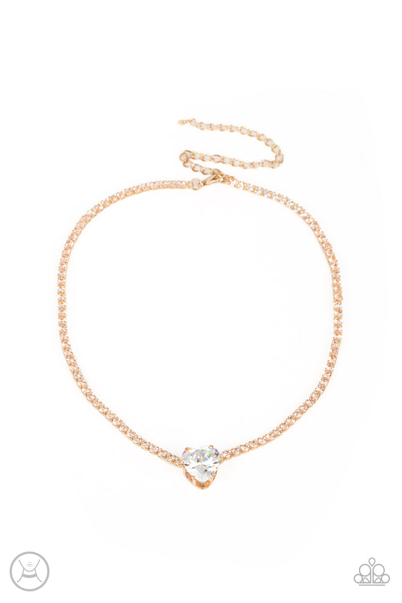 An oversized white heart-shaped gem, set in an airy, pronged gold fitting, glitters at the center of a blinding row of dainty, glassy white rhinestones set in square gold fittings, resulting in a flirtatious sparkle around the neckline. Features an adjustable clasp closure.  Sold as one individual choker necklace. Includes one pair of matching earrings.