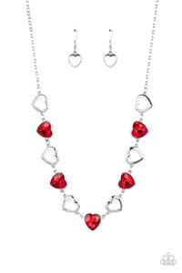 Shiny, silver silhouette hearts alternate between faceted red heart gems pressed into silver frames.The high-sheen and sparkly display coalesce around the collar for a cupid-like charm. Features an adjustable clasp closure.  Sold as one individual necklace. Includes one pair of matching earrings.