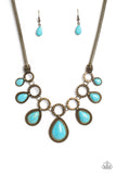 An airy mesh chain gives way to a collection of brass rings that link along the collar. A rustic dot motif decorates three of the rings, alternating with the remaining hoops that feature a subtle hammered texture. A polished turquoise stone teardrop falls from each brass hoop, graduating in size as they lead to the center. Features an adjustable clasp closure. As the stone elements in this piece are natural, some color variation is normal.  