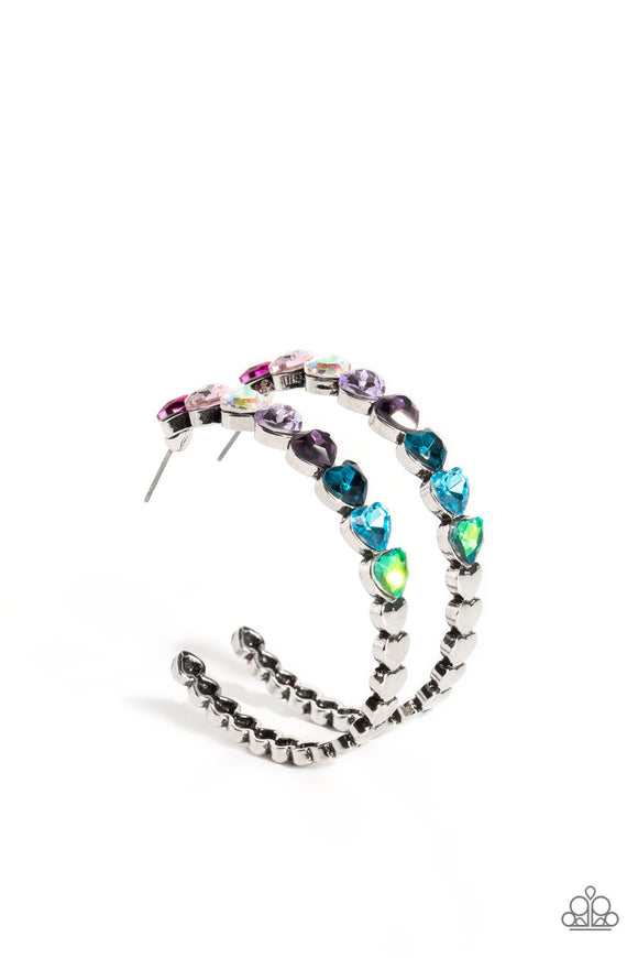 Featuring a scalloped heart frame, glittery heart rhinestones in shades of pink, iridescence, purple, blue, and a refracted green shimmer slowly decrease in size as they curve down the ear to meet dainty silver hearts for a romantic statement. Earring attaches to a standard post fitting. Hoop measures approximately 1 3/4