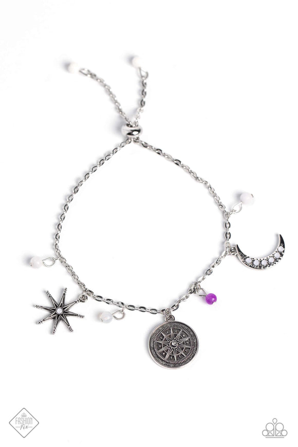 Dainty white stones and an amethyst bead swing from a dainty silver chain, alternating with three wanderlust-inspired charms. The charms include a three-dimensional, studded silver star and a crescent moon, each dotted with opalescent rhinestones, along with an antiqued silver disc embossed with compass details. Features an adjustable sliding closure. As the stone elements in this piece are natural, some color variation is normal.  Sold as one individual bracelet.