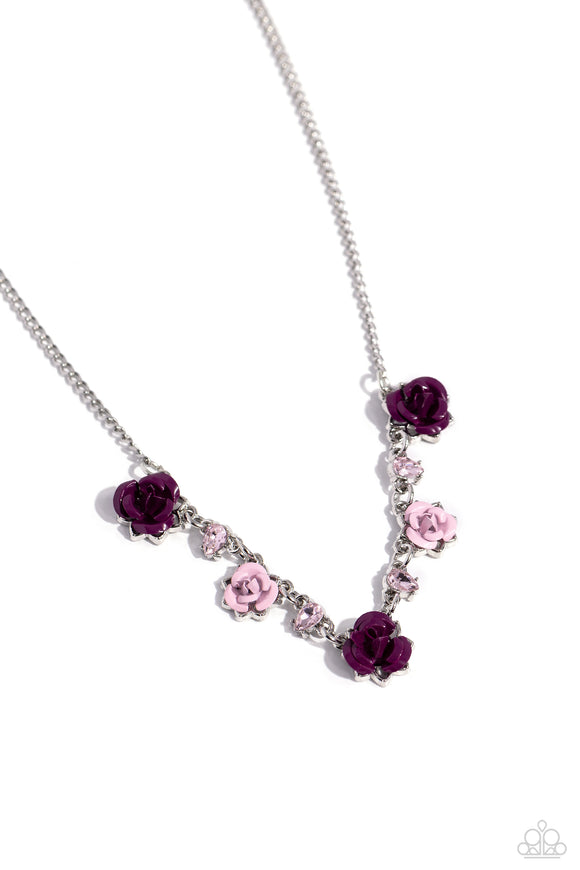 Painted in plum and baby pink hues, various metal roses delicately alternate with upside-down pink teardrop gems across a dainty silver chain, blooming into a seasonal centerpiece. Features an adjustable clasp closure.  Sold as one individual necklace. Includes one pair of matching earrings.