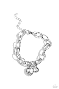 A simple collection of silver charms — including a white rhinestone heart pressed in a silver frame and a sleek letter "J" — dance from a chunky silver chain around the wrist, creating a sentimental fringe. Features an adjustable clasp closure.  Sold as one individual bracelet.