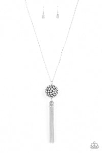 Infused with silver studded fittings, a glittery collection of sparkly white rhinestones coalesce into a dramatic pendant at the bottom of a lengthened silver chain. Capped in a rhinestone dotted frame, a shimmery silver tassel streams out from the blinding pendant for a flirtatious finish. Features an adjustable clasp closure.  Sold as one individual necklace. Includes one pair of matching earrings.